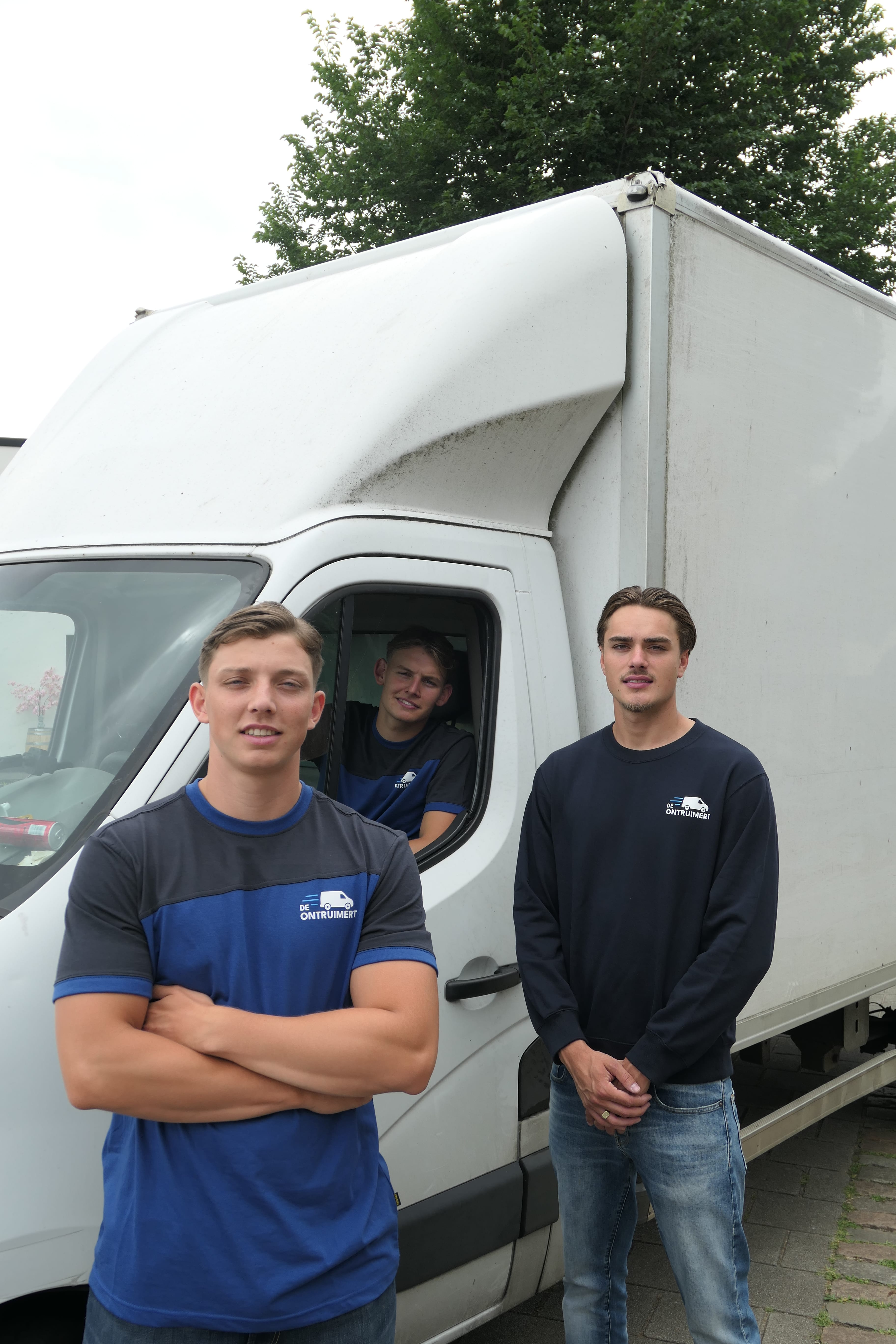 Drie ontruimers bij een witte werkbus